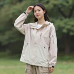 여름 여성 자켓 스타일링 팁 파스텔톤 여름 여성 경량 바람막이 자켓을 입고 야외에서 포즈를 취한 모습